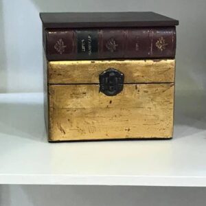 Scatola piccola dorata a foglia con libro antico
